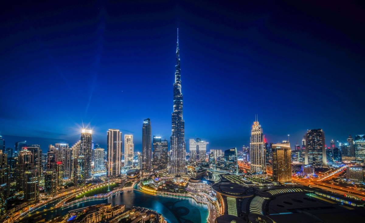 Nighttime Dubai skyline: Burj Khalifa & skyscrapers glowing with vibrant lights—stunning urban view.