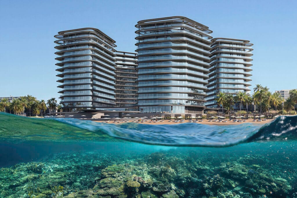 Brabus Island beachfront towers with oceanfront view and visible coral reef in Umm Al Quwain, UAE.