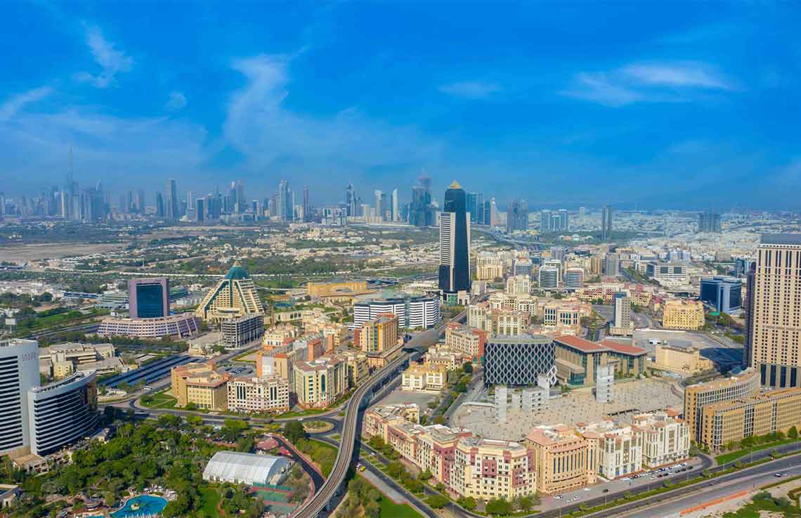 Aerial view of Al Jaddaf in Dubai with modern buildings, highways, and the Business Bay skyline in the background.