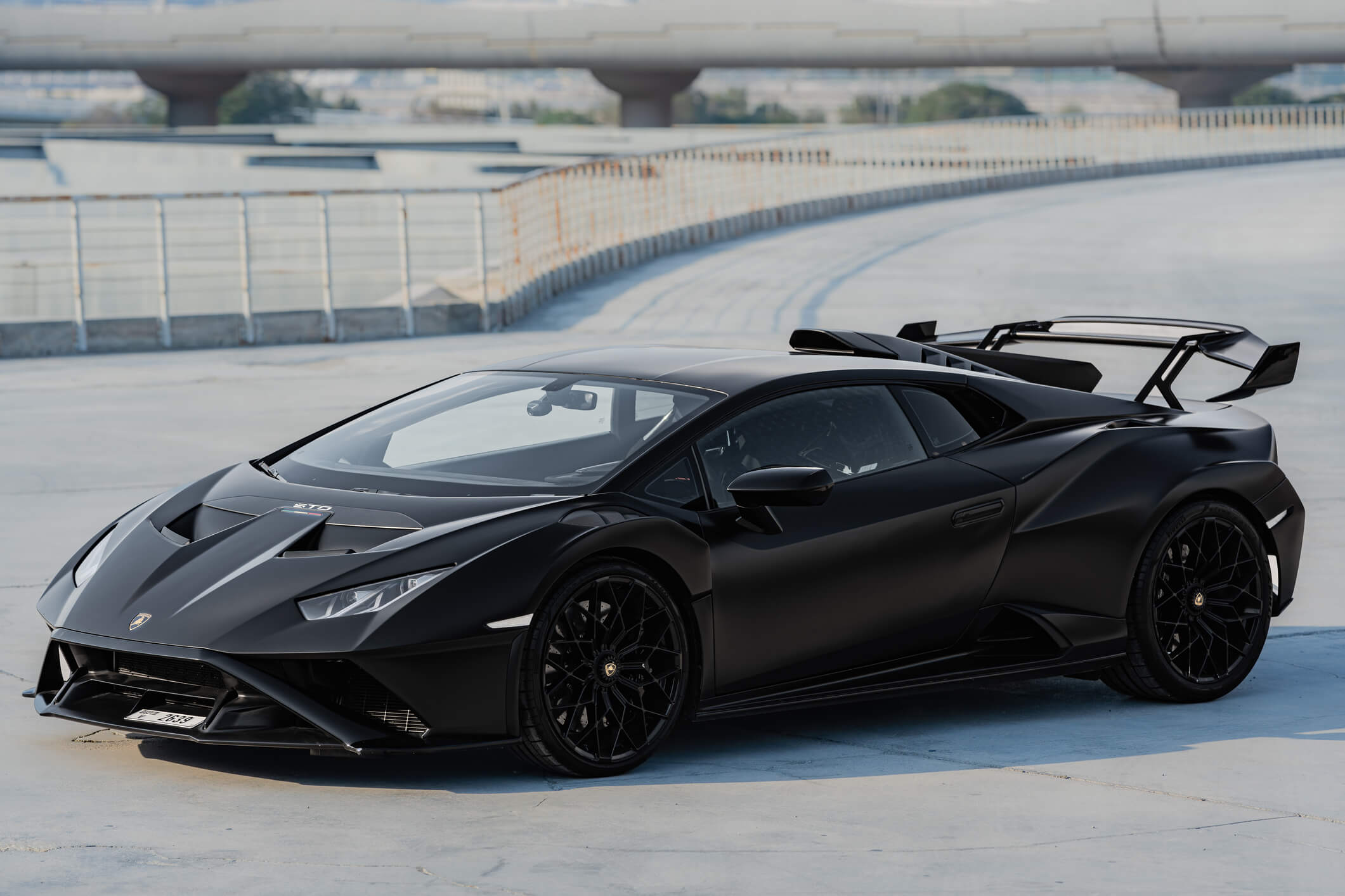 Matte black Lamborghini Huracan STO parked on rooftop in Dubai – available for rent from Solid Cars