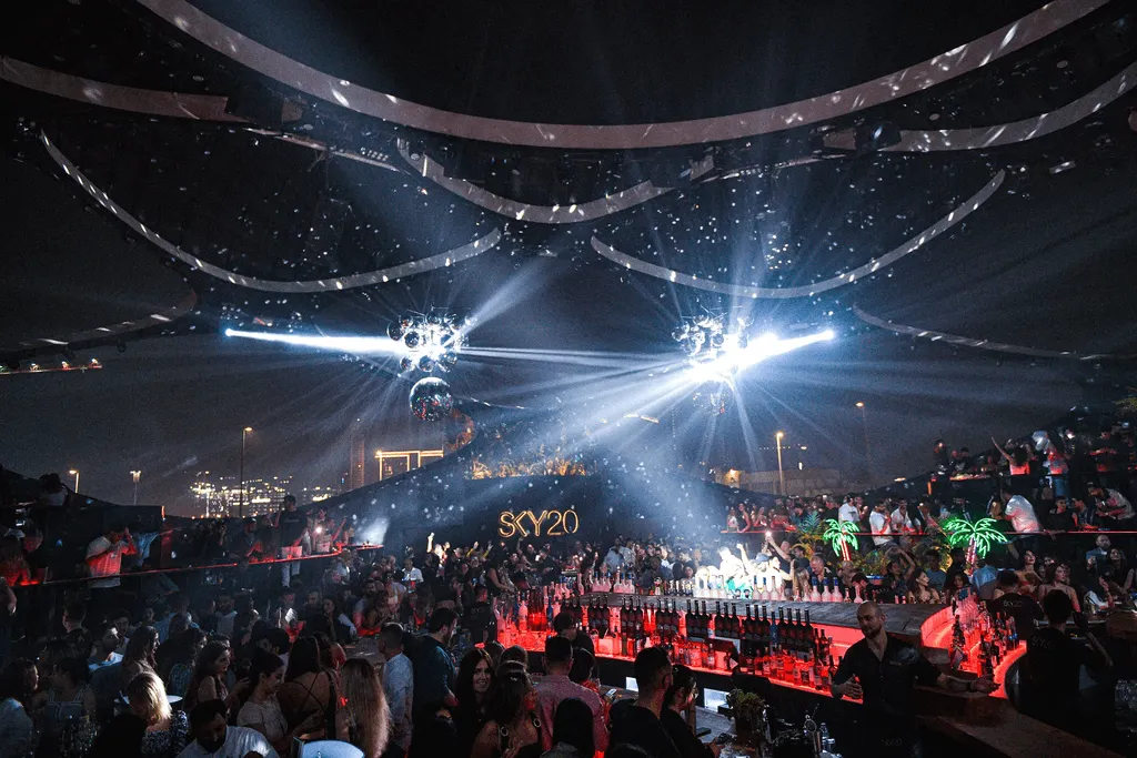 Sky 2.0 Dubai nightclub packed with partygoers, dazzling lights, bar scene, and vibrant nightlife energy.