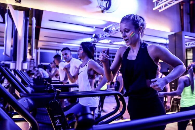 Group cardio session at BARE Fitness Dubai with neon lighting and high-energy HIIT workout atmosphere in 2025.