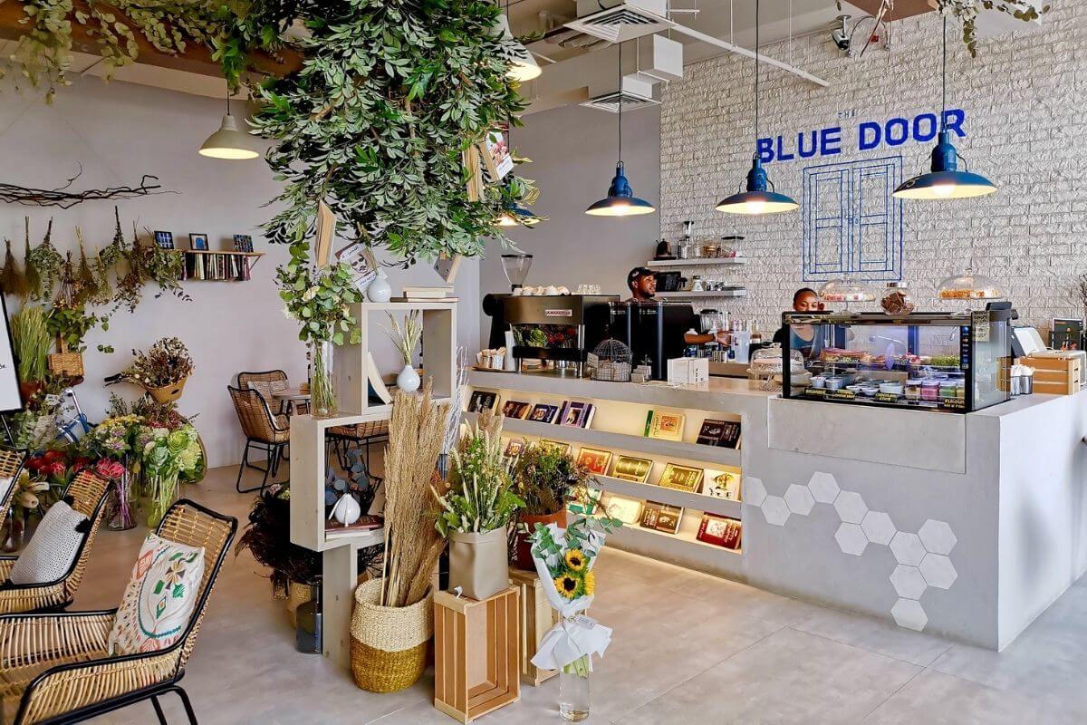 Blue Door Café in Jumeirah, Dubai — cozy coffee and flower shop with books, plants, and artisan desserts.