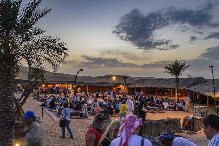 Evening desert safari camp in Dubai with traditional seating, food, and entertainment — a must-do cultural experience in the UAE.