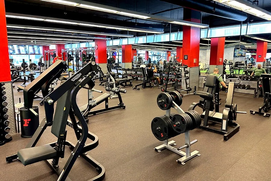 Modern gym interior at Fitness First Dubai with strength machines, weights, and fitness equipment in 2025.