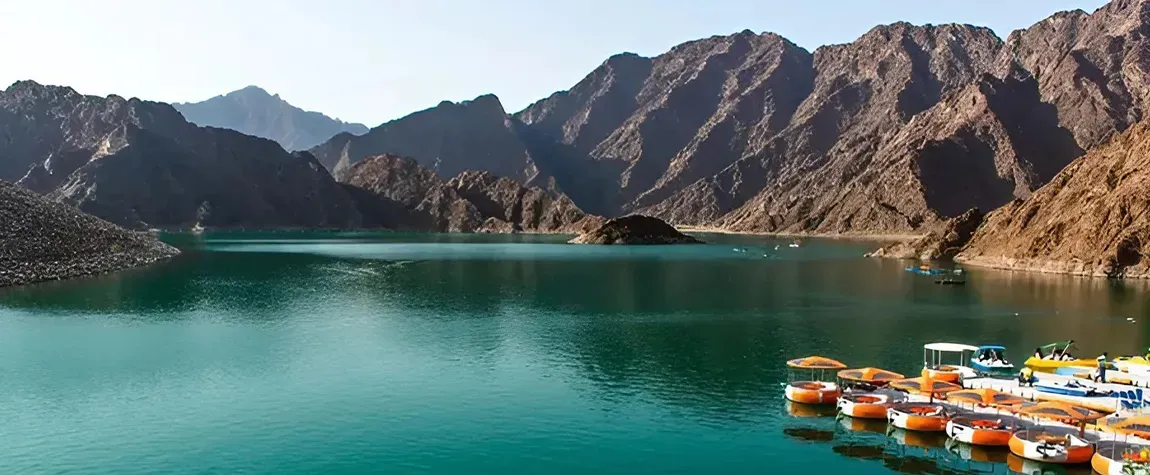 Colorful pedal boats docked at Hatta Dam, Dubai — a scenic mountain lake popular for kayaking and nature escapes in the UAE.