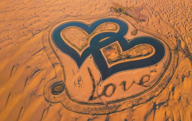 Heart-shaped Love Lake in Al Qudra Desert, Dubai — a romantic man-made oasis surrounded by sand dunes.