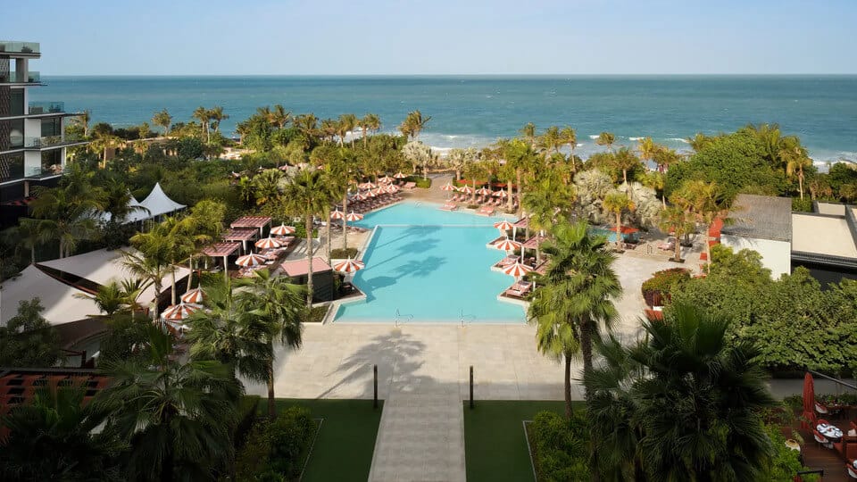 Luxury resort pool with sunbeds, palm trees and ocean view at Bluewaters Island Dubai