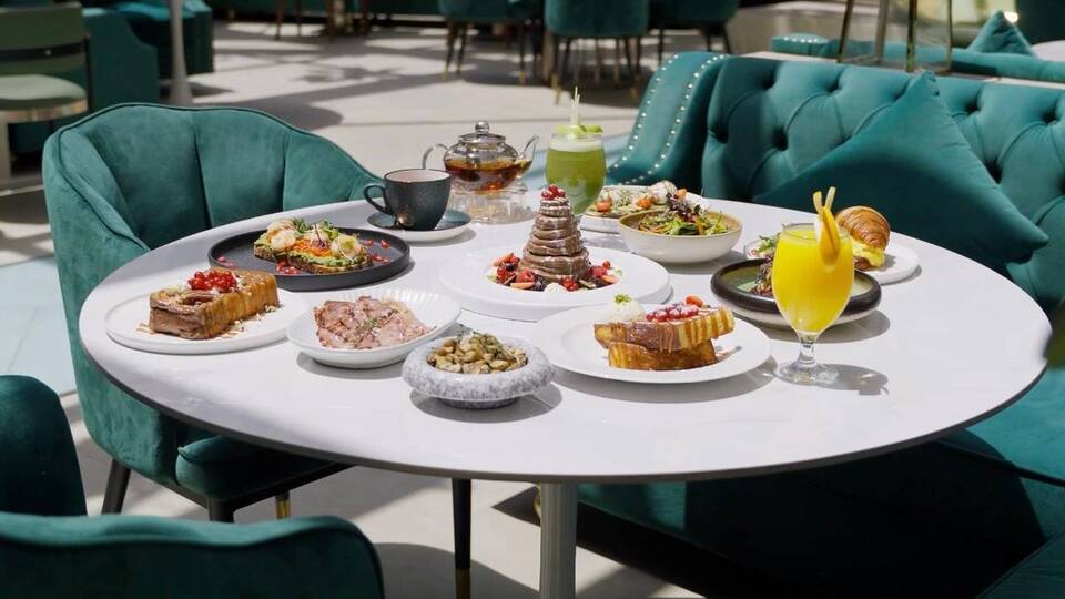Elegant breakfast and brunch spread with fresh juice, pastries, salads and desserts at a Dubai cafe