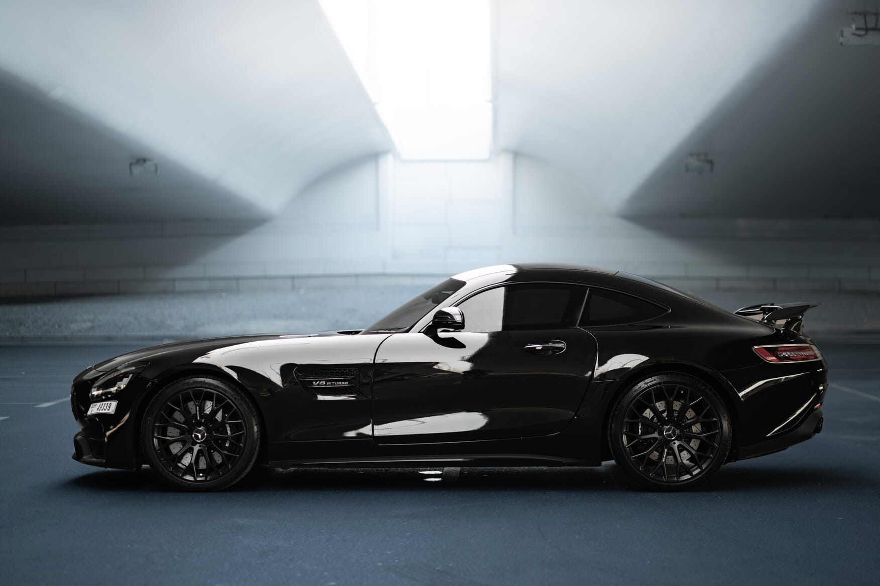 Full side profile of black Mercedes-AMG GT Night Edition parked in Dubai, luxury sports car for rent with Solid Cars
