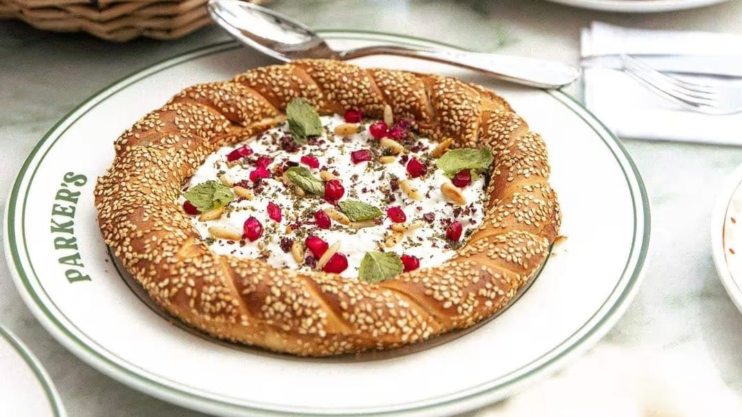 Sesame simit bread ring filled with labneh, pomegranate and herbs served at Parker's Dubai for breakfast