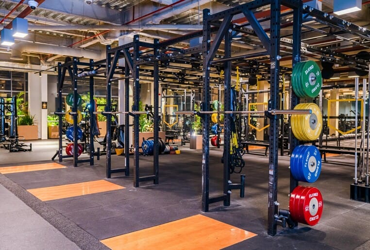 Weightlifting area at The Warehouse Gym Dubai featuring squat racks, bumper plates, and functional fitness setup in 2025.