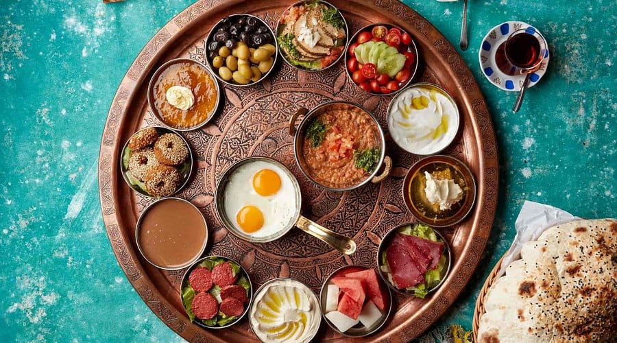 Traditional Arabic breakfast platter with eggs, mezze, bread and tea served at Zouzou Dubai