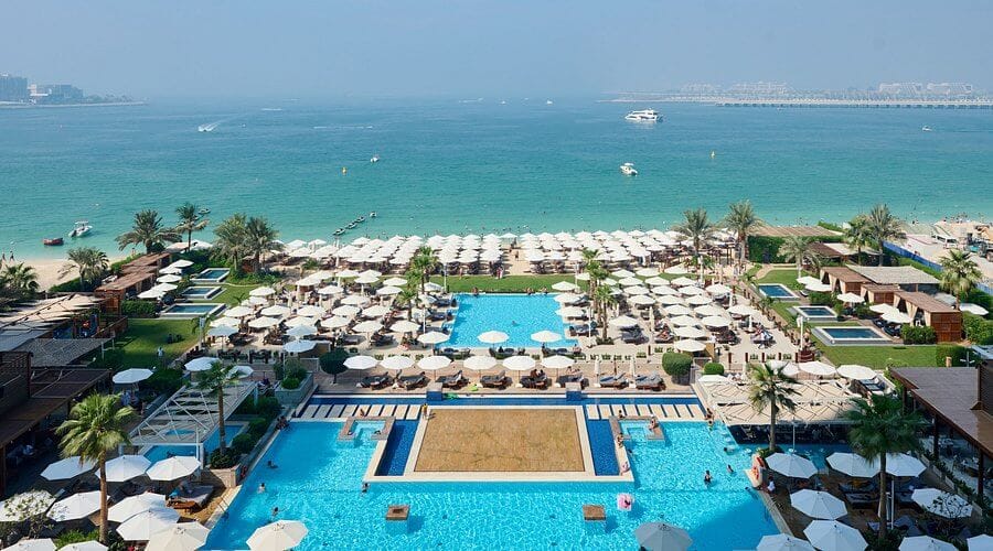 Aerial view of Azure Beach at Rixos Premium JBR with pools, sunbeds, and stunning Dubai Marina sea view