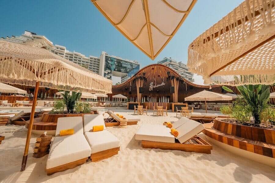 Luxury sunbeds and fringe umbrellas on the sandy beach at Bohemia Beach Club in Dubai
