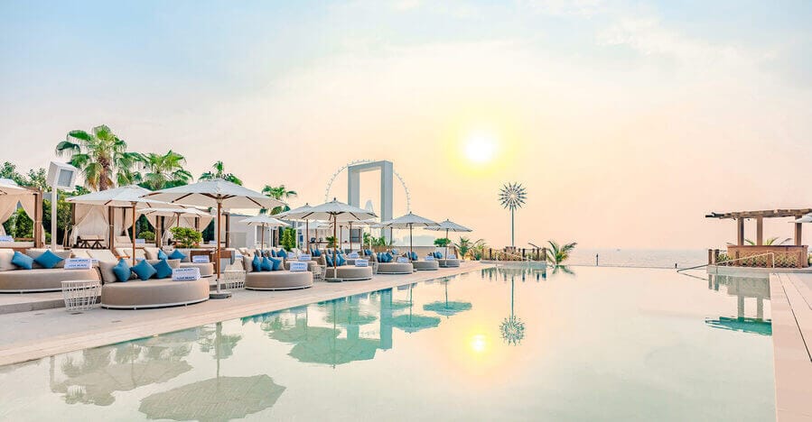 Infinity pool at Cove Beach with Dubai Frame and sea view at sunset near Jumeirah Beach Hotel