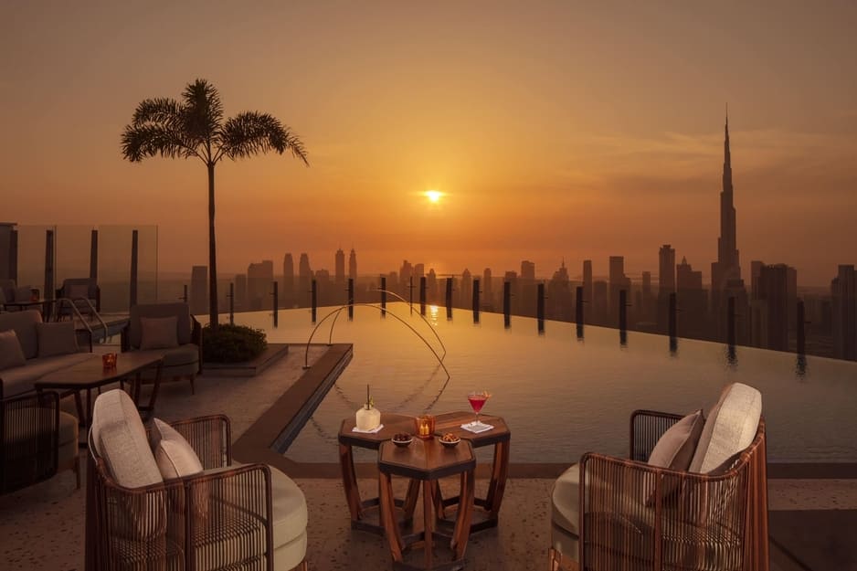 Privilege rooftop at SLS Dubai with infinity pool, sunset skyline view, and Burj Khalifa in the background