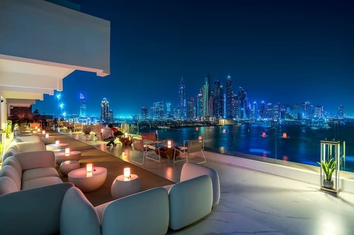 The Penthouse at FIVE Palm Jumeirah with chic rooftop lounge and breathtaking Dubai Marina skyline at night