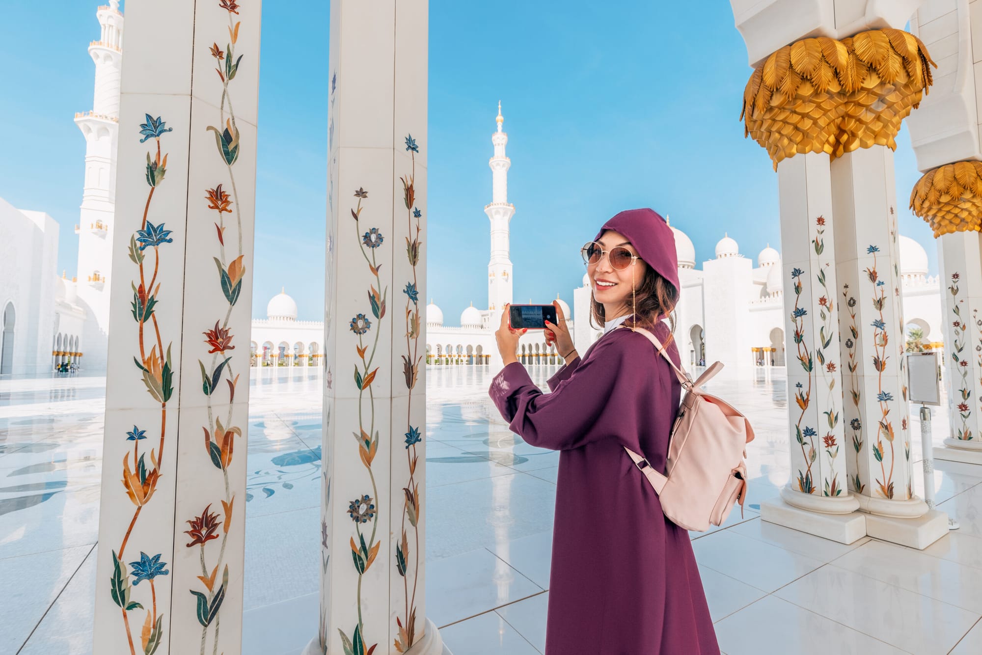 Tourist woman wearing abaya at Sheikh Zayed Grand Mosque in Abu Dhabi, dressed modestly for cultural visit