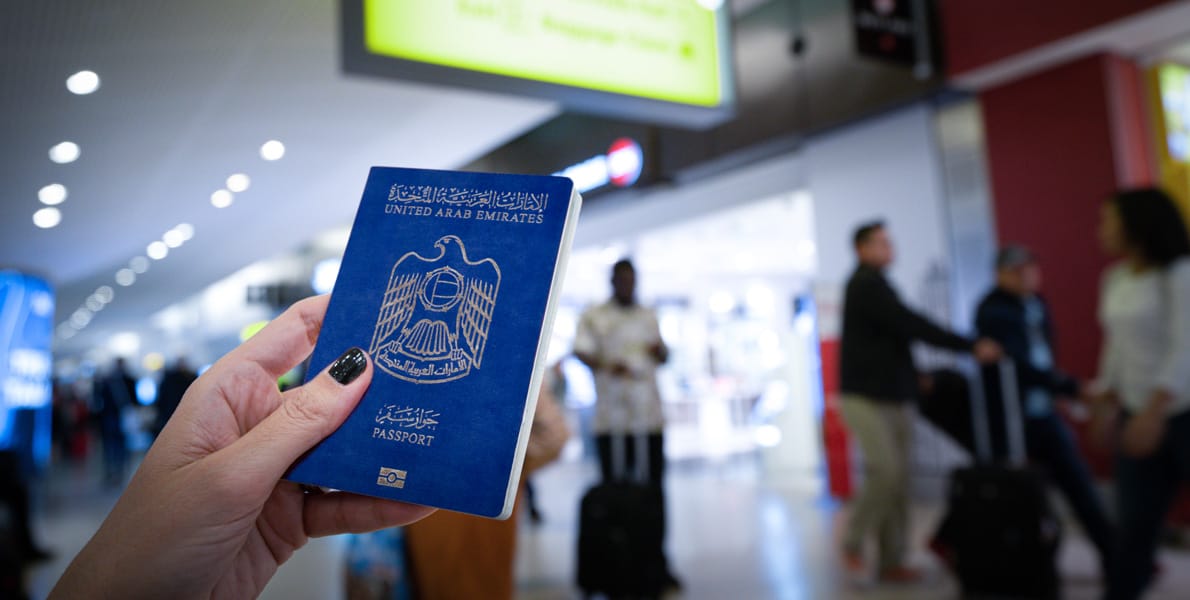 Traveler holding UAE passport at airport before flight – importance of Dubai travel insurance in 2025