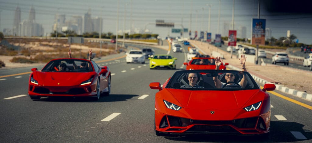 Convoy of Lamborghini and Ferrari supercars driving in Dubai for luxury car rental experience