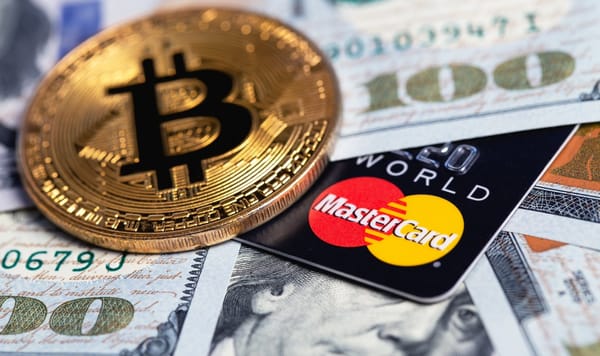 Bitcoin coin with Mastercard credit card and USD cash in background.