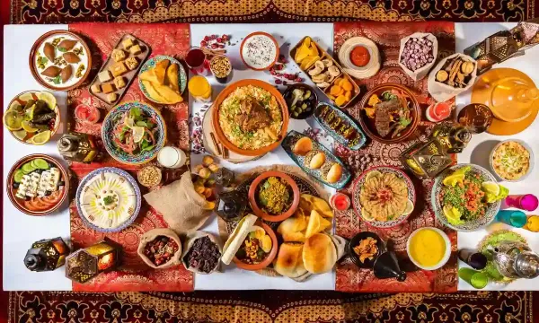 Traditional Emirati Iftar feast in Dubai with assorted dishes, breads, salads, and desserts on a decorative table setting.