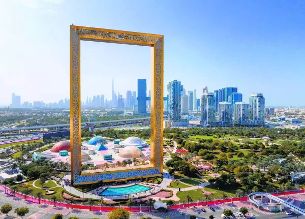 Aerial view of Dubai Frame with skyline and Zabeel Park in the background on a clear day.