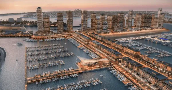 Aerial sunset view of Dubai Harbour Marina with luxury yachts, modern buildings, and Palm Jumeirah in the background