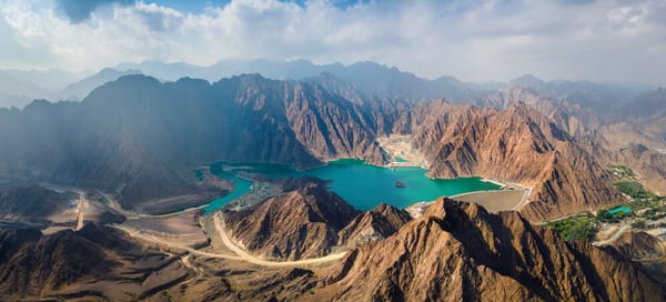 Aerial view of Hatta Dam surrounded by rugged mountains — a popular nature retreat and kayaking spot near Dubai, UAE.