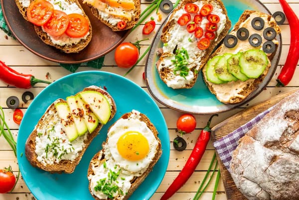 Colorful open sandwiches with egg, veggies, cheese and fresh bread served for breakfast at a Dubai cafe