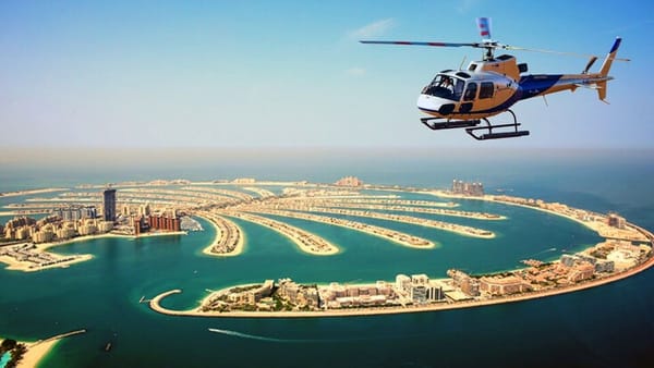 Helicopter flying over Palm Jumeirah in Dubai with stunning aerial view of the iconic island and coastline