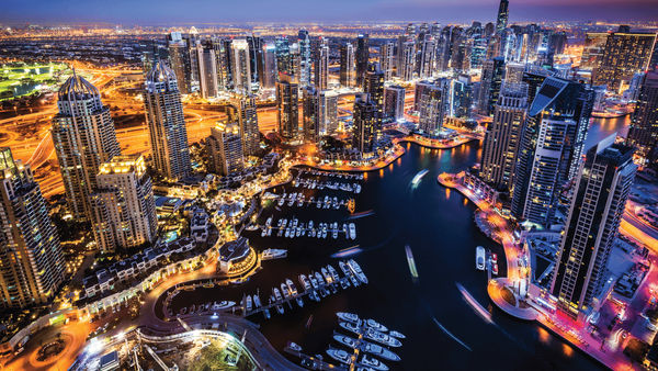Dubai Marina skyline at night with waterfront apartments and yachts in one of Dubai’s prime freehold property zones